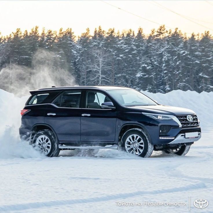 a black suv is driving through the snow