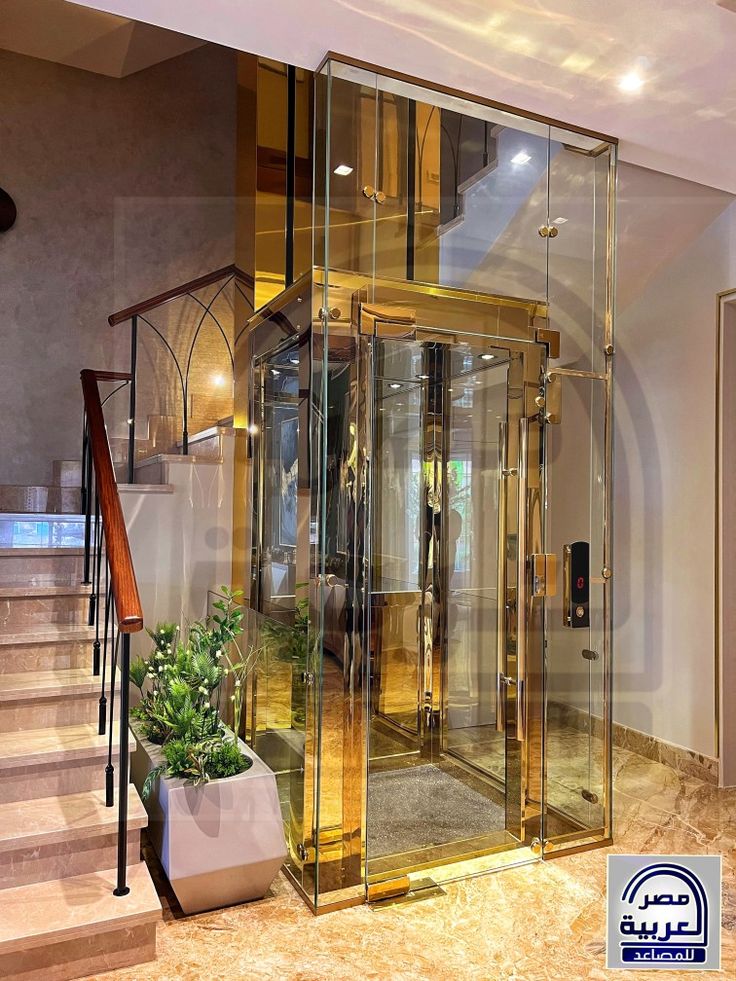 the inside of a building with glass walls and stairs leading up to an indoor elevator