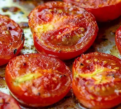 sliced tomatoes on a baking sheet ready to be cooked