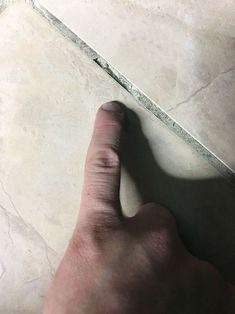 a person's hand on the ground with their thumb in the middle of the floor