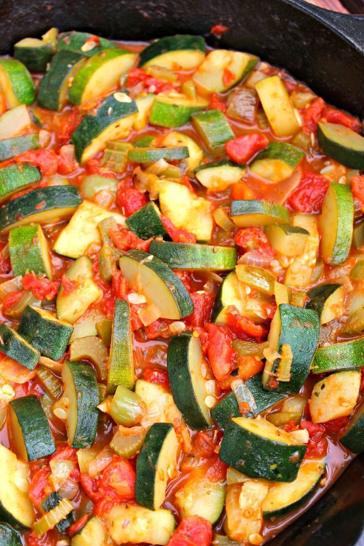 an iron skillet filled with cooked zucchini and tomatoes