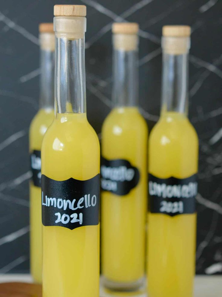 three bottles filled with lemonade sitting on top of a table