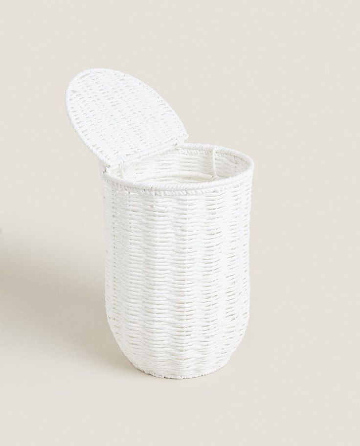 a white wicker basket with lid sitting on a table