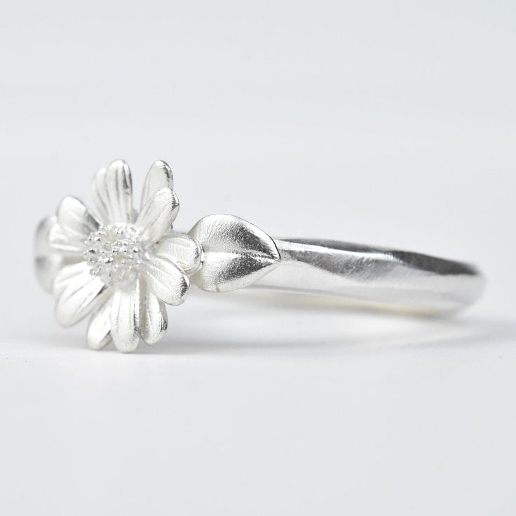 Handmade in USA Bright white matte pickled finish 925 Sterling silver Flower and leaves measure 1/2" inch across Ring size US 7 This ring can be re-sized within sizes 5-9 at no extra charge. If you would like ring sized, please send us a message! Goldmakers Jewelry Mission Statement Goldmakers Jewelry creates and curates a comprehensive selection of artfully designed hand-crafted jewelry. We aspire to offer the jewelry enthusiast access to affordable classics as well as fresh innovative designs. Daisy Ring, Sterling Silver Flowers, Jewelry Maker, Silver Flowers, Classic Elegance, Metal Sculpture, Bright White, Innovation Design, Handcrafted Jewelry