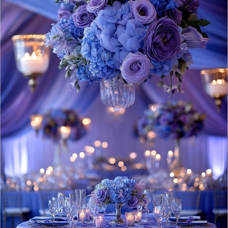 the centerpieces are filled with purple flowers and lit candles for an elegant wedding reception