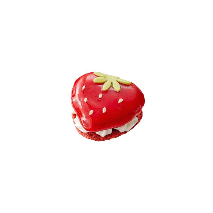 a strawberry shaped pastry with white frosting and green sprinkles on top