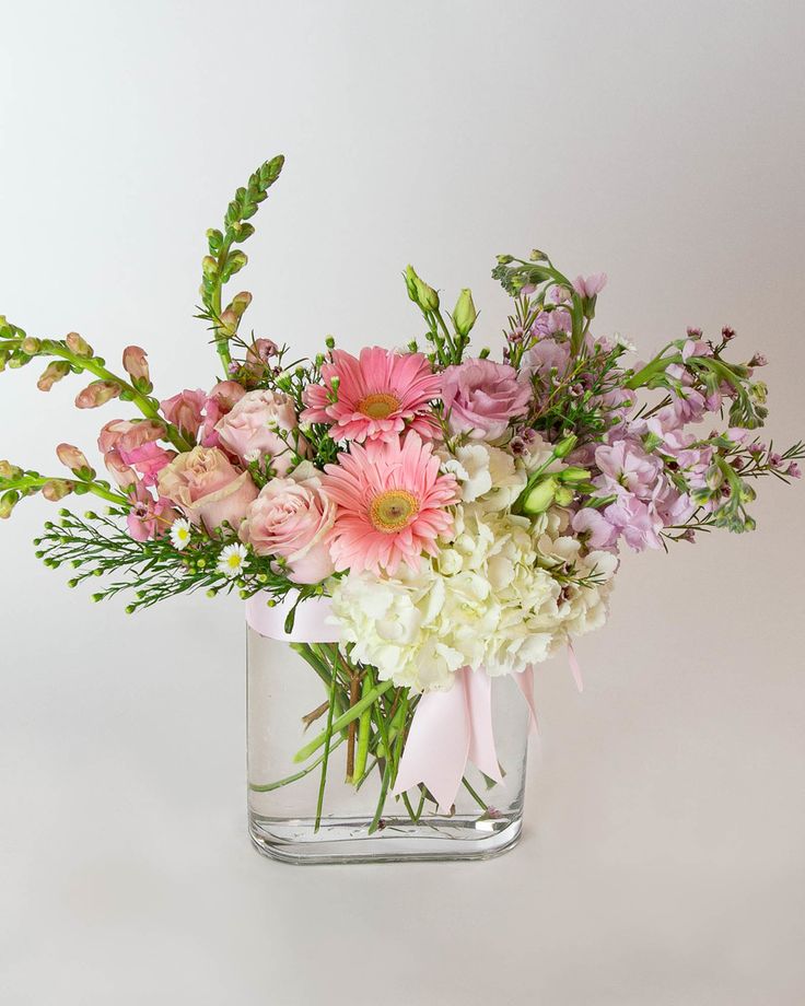 a vase filled with lots of pink and white flowers