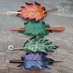 three different colored leaves on top of each other with knitting needles sticking out of them