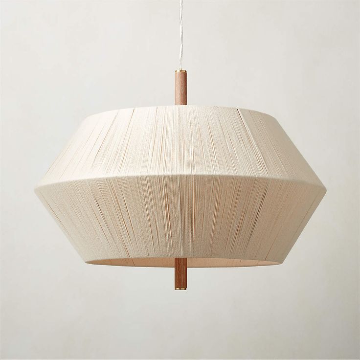 a white light hanging from a ceiling fixture with a wooden stick sticking out of it