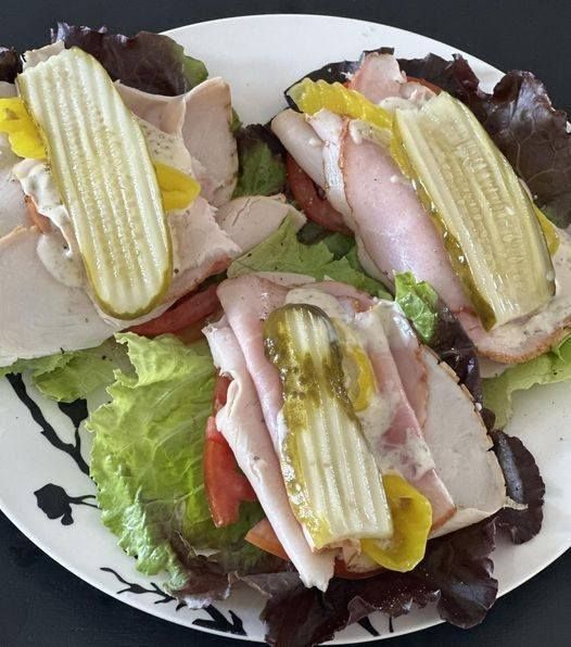 a white plate topped with sandwiches covered in lettuce