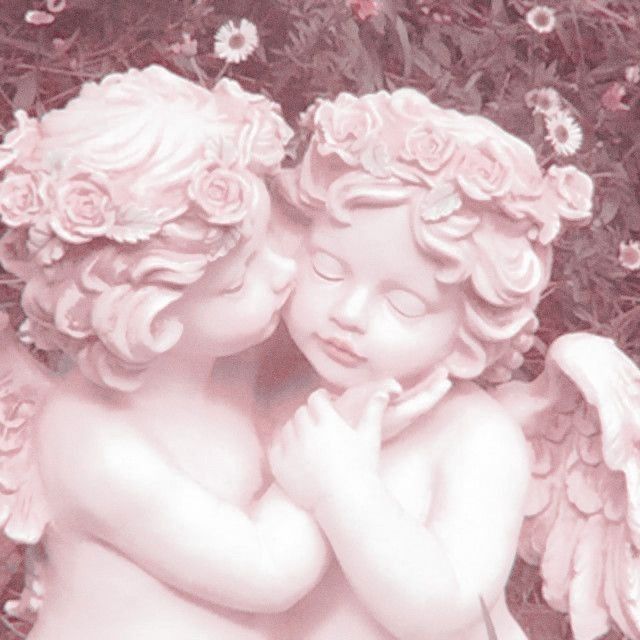 two cherubs with pink roses on their heads are touching each other's hands