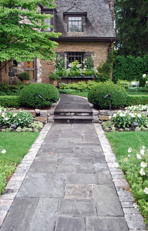 a stone walkway leading to a large house