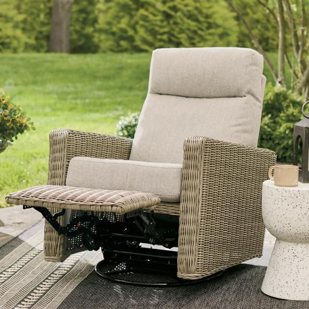 a reclining chair sitting on top of a wooden deck next to a potted plant