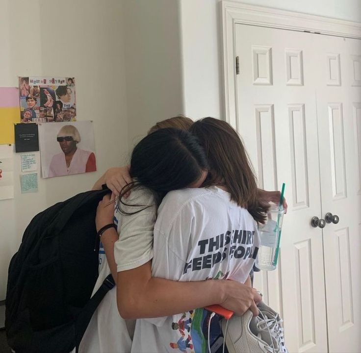 two girls hugging each other in front of a door