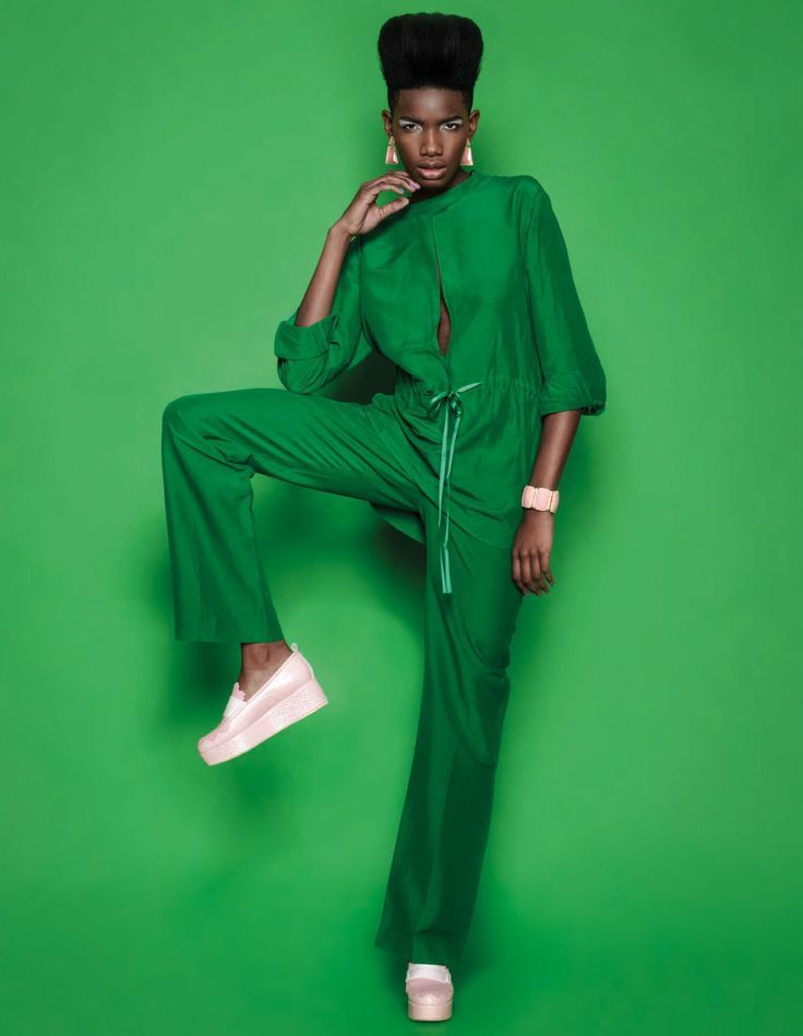 a woman in green is posing for the camera