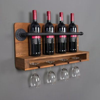 four wine glasses are sitting on a wooden shelf next to three bottles of wine and one glass is hanging from the wall