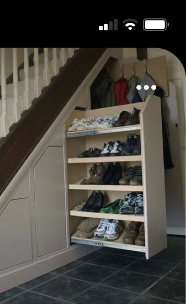 an under stair storage unit with shoes and other items