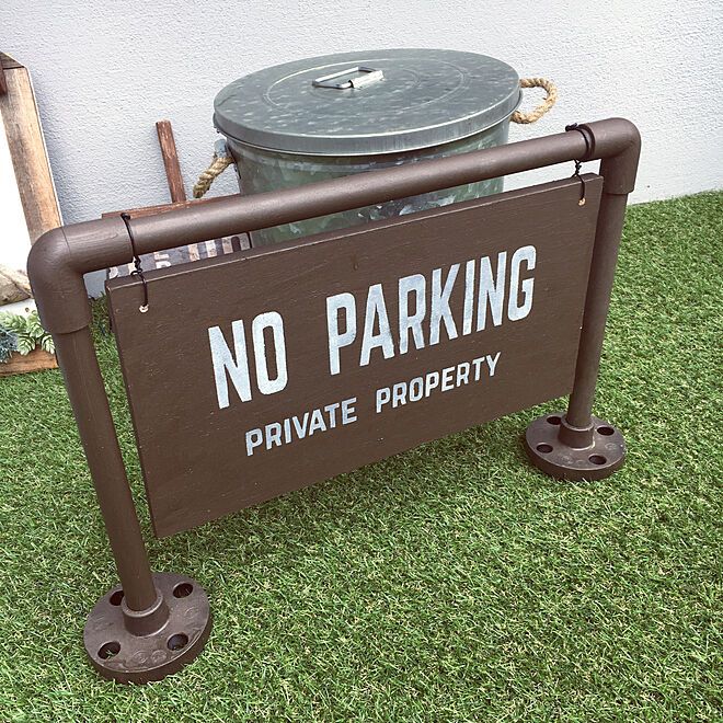 a no parking private property sign in front of a trash can on the grass area