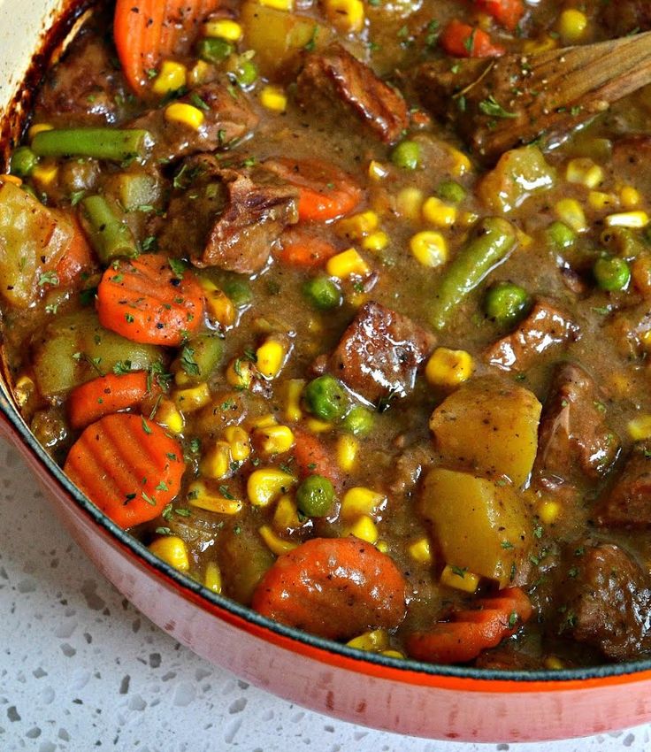 a pot filled with stew and vegetables on top of a table