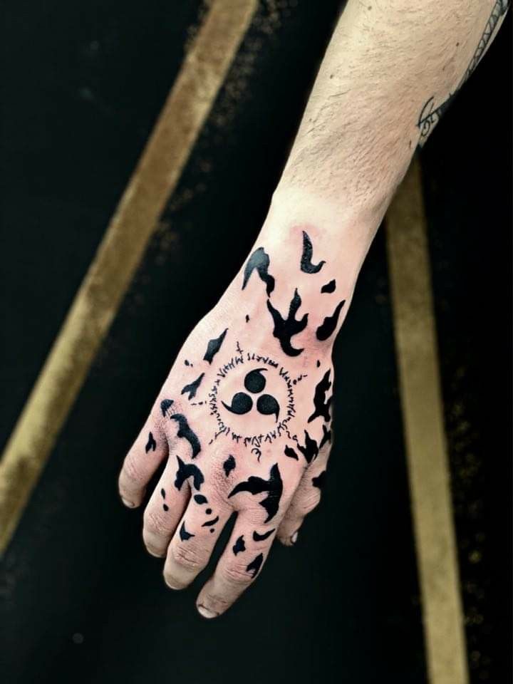 a person's hand with black ink on it and birds flying around the wrist