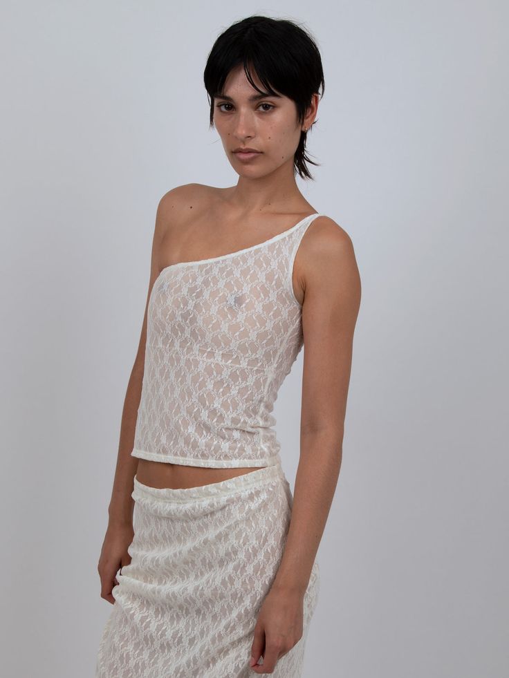 ONE SHOULDER TOP IN WHITE LACE – B U C I Fitted Lace Mesh Top With Lace Trim, White Fitted One-shoulder Top, Fitted White One Shoulder Top, White Lace Mesh Top For Party, White Sleeveless Top With Scalloped Lace, White Delicate Lace Crop Top For Summer, Fitted White Lace Mesh Top, White Sleeveless Scalloped Lace Top, Sheer Fitted Summer Lace