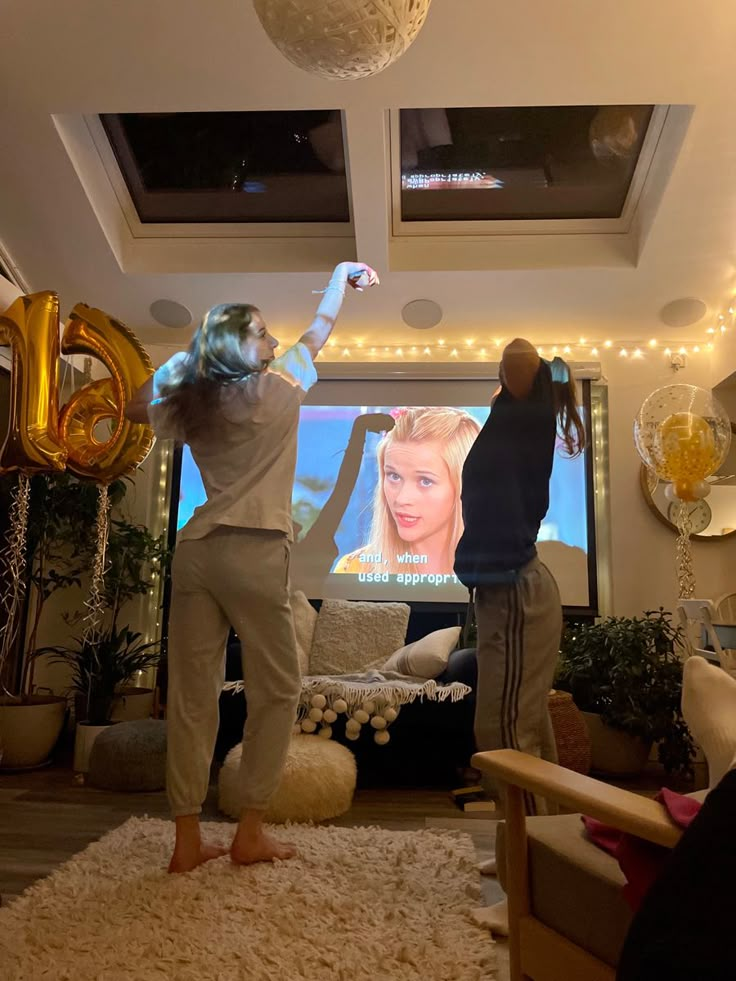 two people standing in front of a flat screen tv