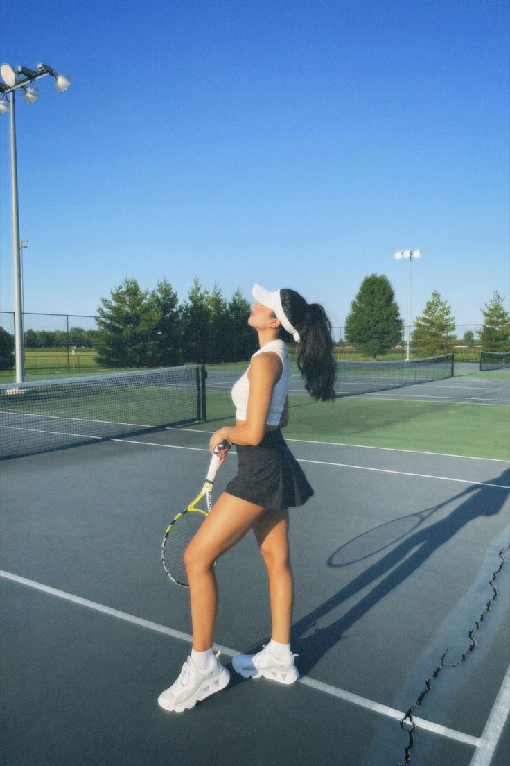 a woman standing on top of a tennis court holding a racquet in her hand