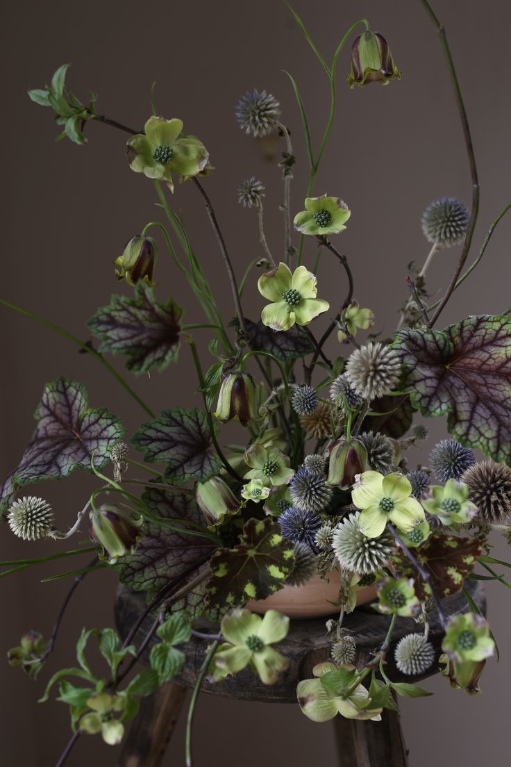 a vase filled with lots of flowers on top of a table