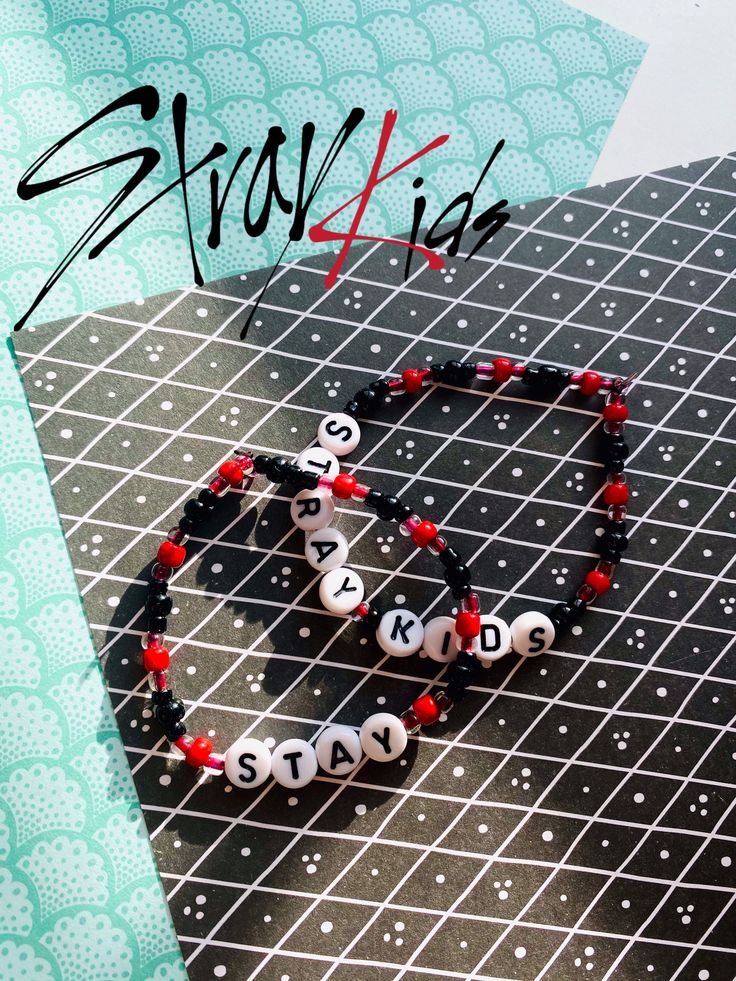 two bracelets on top of a table with the word love spelled in black and white letters