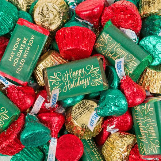 many different types of candy wrapped in red and green foil with the words merry christmas written on them