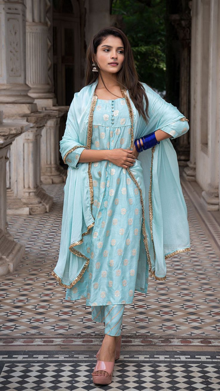 Bring on the festive spirit with our silk kurta set Made in woven silk with golden zari Fully lined kurta and pants Dupatta made in Chiffon with Gota border Color : Powder Blue + Gold Model height is 5.3” and is wearing a size M Wash Care : Dry Clean Only Festive Slub Silk Kurta With Cutdana Detail, Silk Kurta With Cutdana For Diwali, Blue Slub Silk Sets For Festive Occasions, Bollywood Slub Silk Palazzo Set For Eid, Diwali Silk Kurta With Cutdana, Festive Blue Slub Silk Set, Festive Cotton Silk Palazzo Set With Traditional Drape, Designer Banarasi Silk Kurta With Gota Work, Slub Silk Palazzo Set With Gota Work For Celebrations