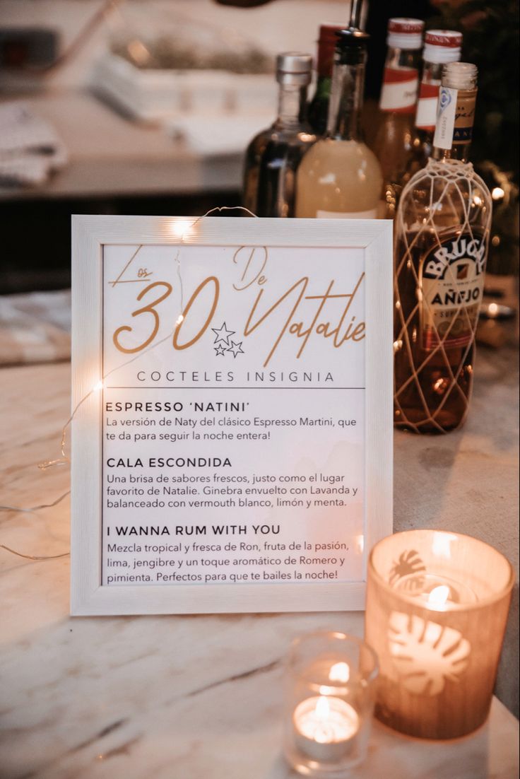 a table with candles, bottles and a sign on it