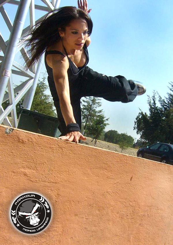 a woman doing a trick on a skateboard in front of a ramp and stairs