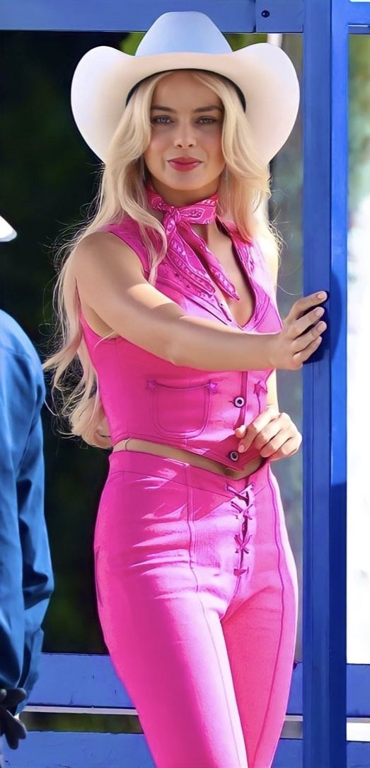 a woman in a pink outfit and cowboy hat