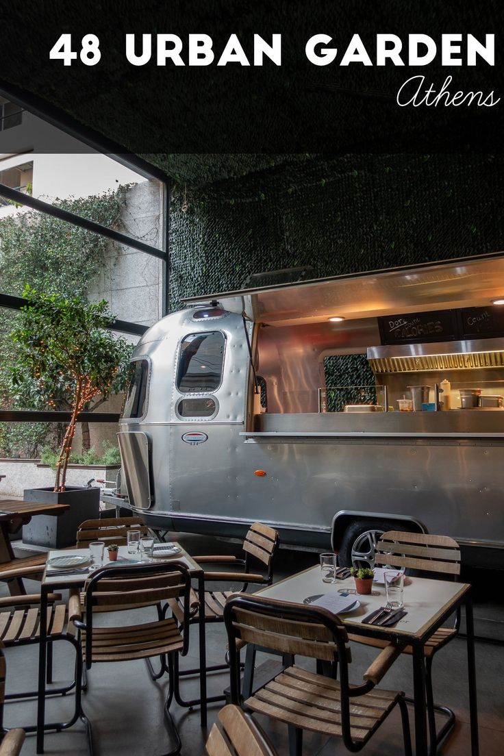 the interior of a restaurant with tables, chairs and an airstream in the background