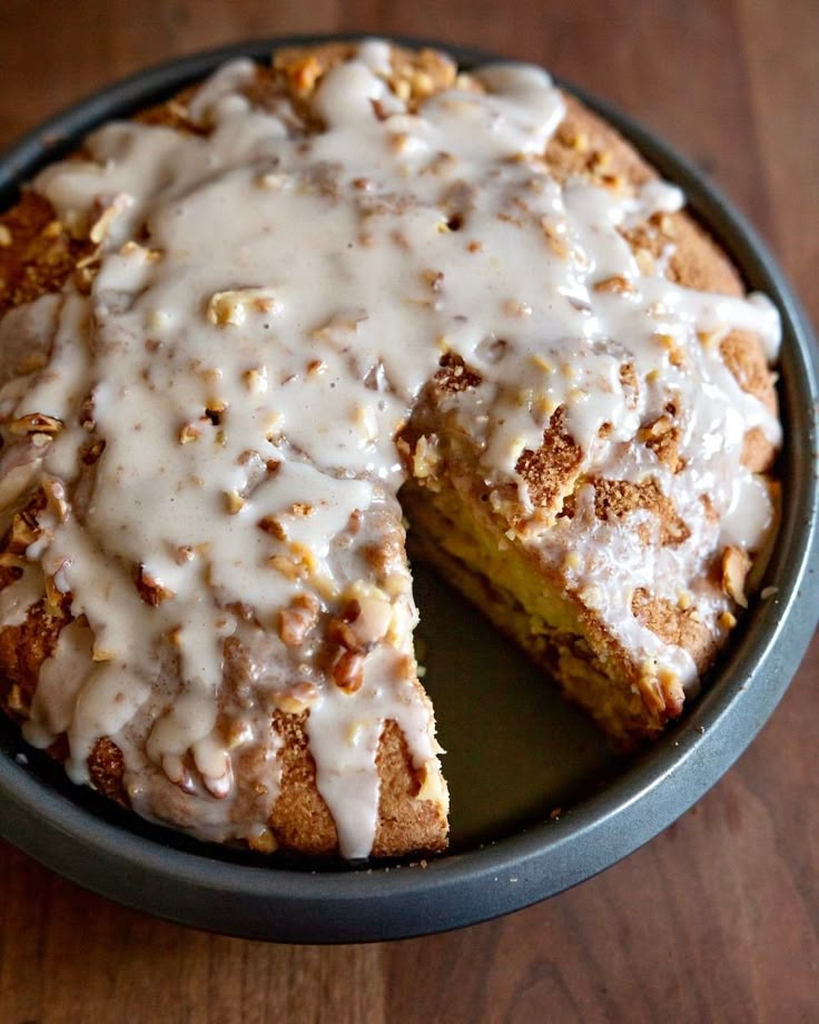 a cake with white icing sitting on top of a wooden table