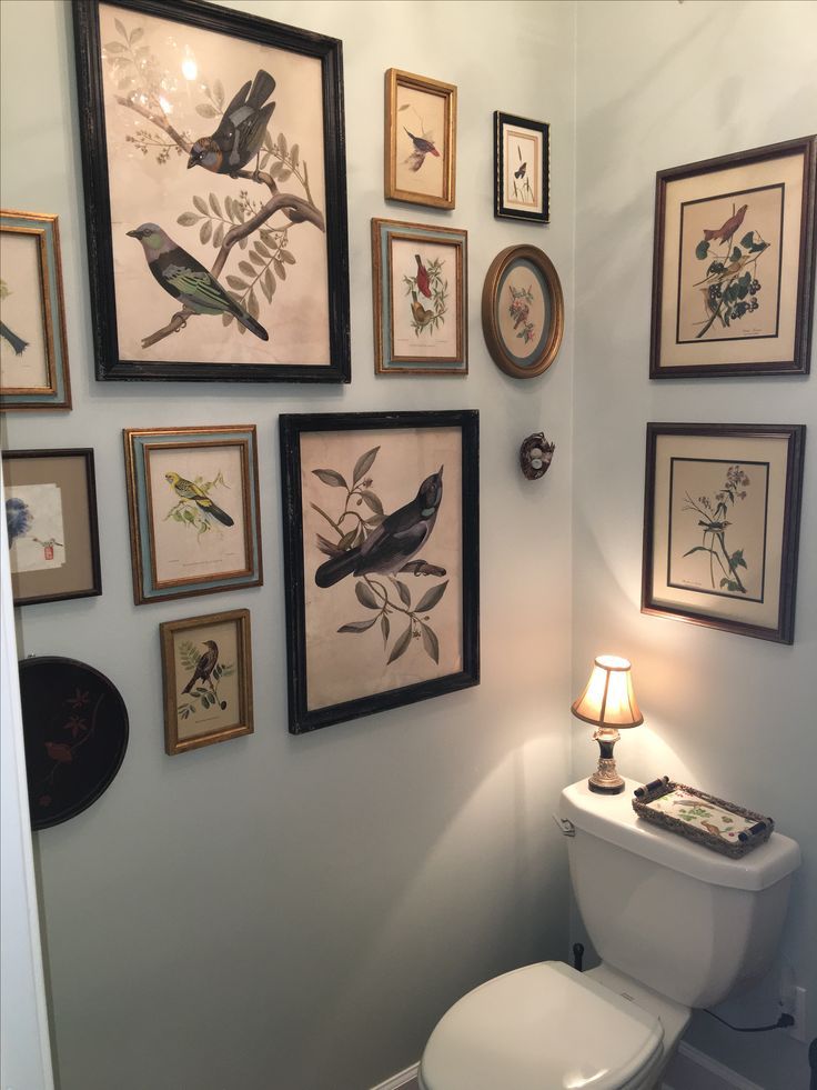 a white toilet sitting in a bathroom next to pictures on the wall