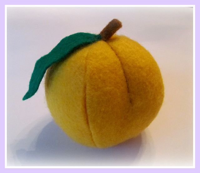 an orange with a green leaf on it's tip sitting on a white surface