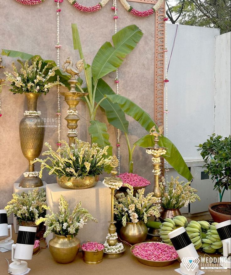 a table topped with lots of vases filled with flowers and greenery next to each other