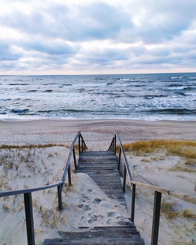 the stairs lead down to the beach from the sand