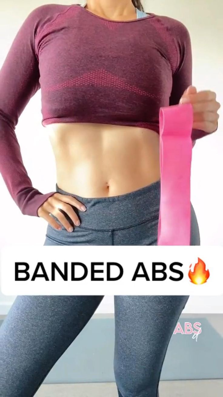 a woman in grey pants holding a pink yoga mat with the words banned abs on it