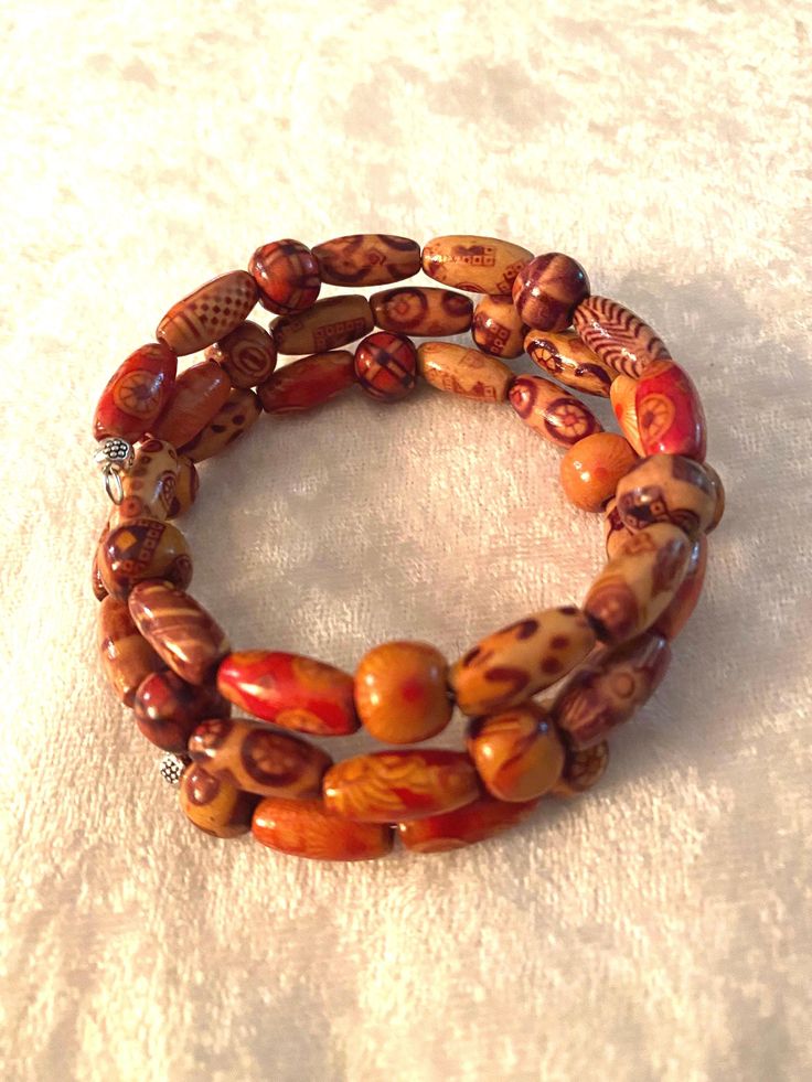 I used two sizes (3x10 rice and 8mm round) of beautiful hand painted wood beads on this 3 loop memory wire. Fits any size. Comes wrapped in a black velvet pouch.  FREE shipping to USA International shipping is calculated  B13 Red Jade Bracelet, Painted Wood Beads, Wood Bead Bracelet, Ruby Bracelet, Dragon Vein Agate, Decorative Wood, Garnet Bracelet, Jade Bracelet, Velvet Pouch