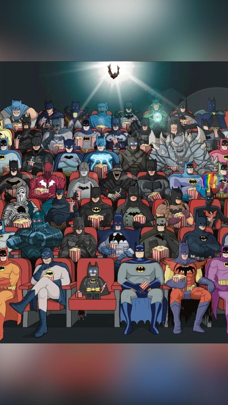 a group of people dressed up as batmans sitting in a movie theater with bats flying overhead