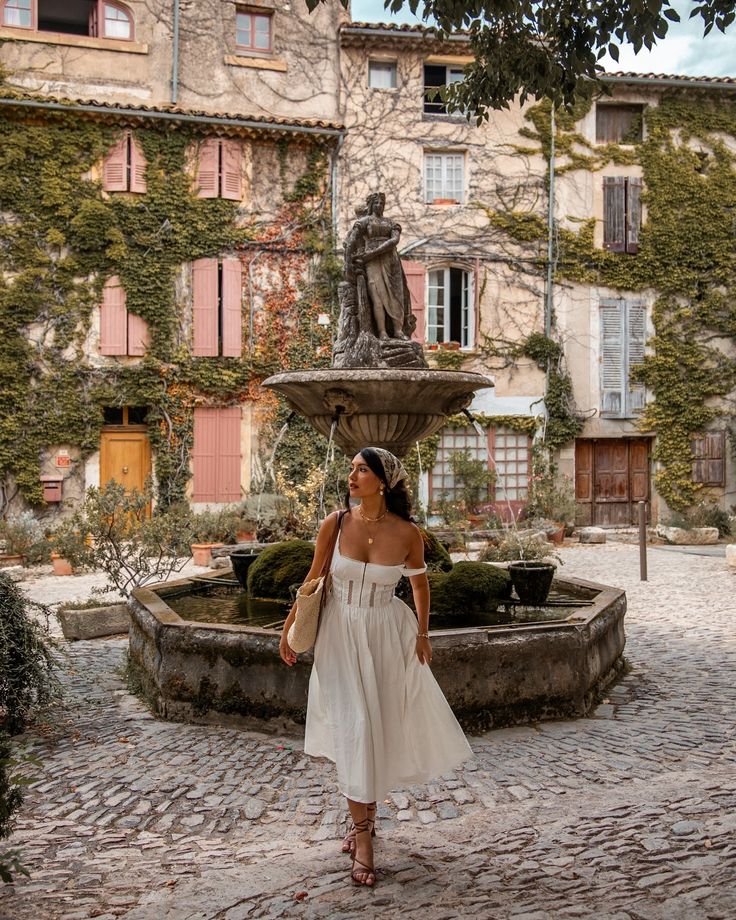 a woman standing in front of a fountain