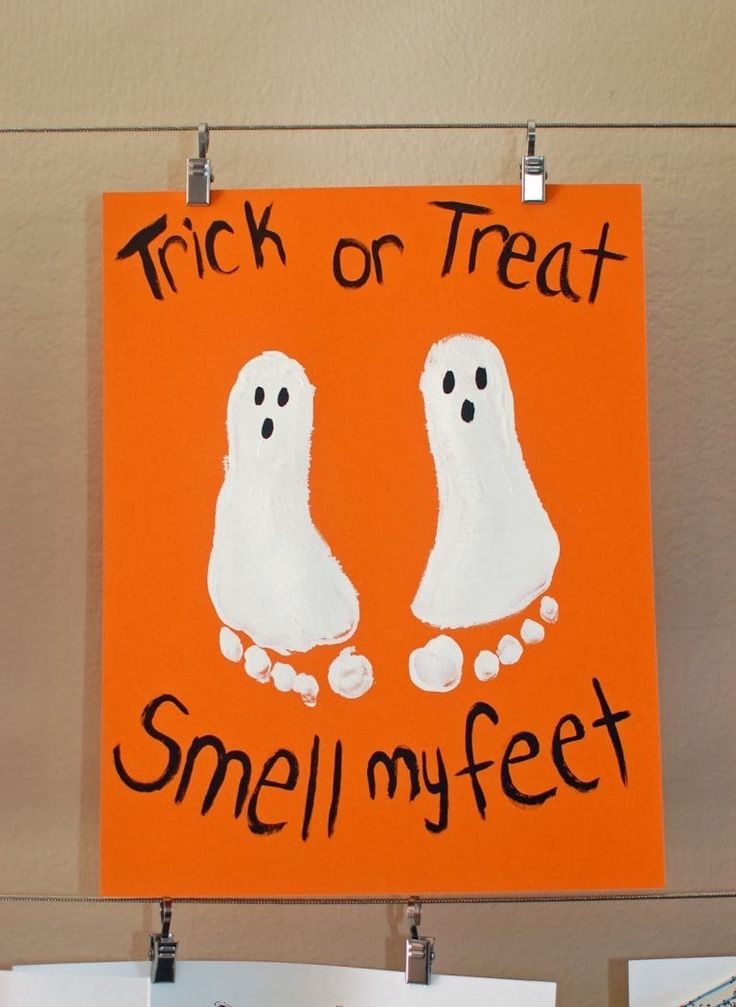 a sign that says trick or treat smell my feet and two ghost hands on an orange background