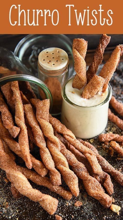 some churro sticks are next to a jar of dip