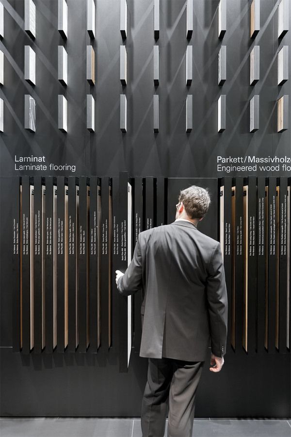 a man standing in front of a black wall with many different types of metal bars on it