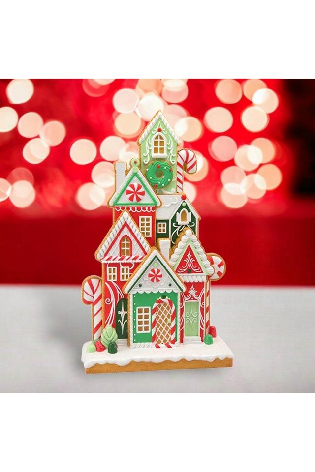 a gingerbread house is decorated with candy canes and christmas lights in the background