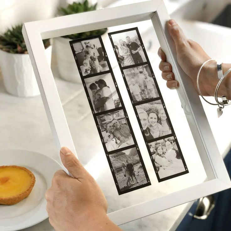 a person holding up a photo frame with photos on it and a donut in the background