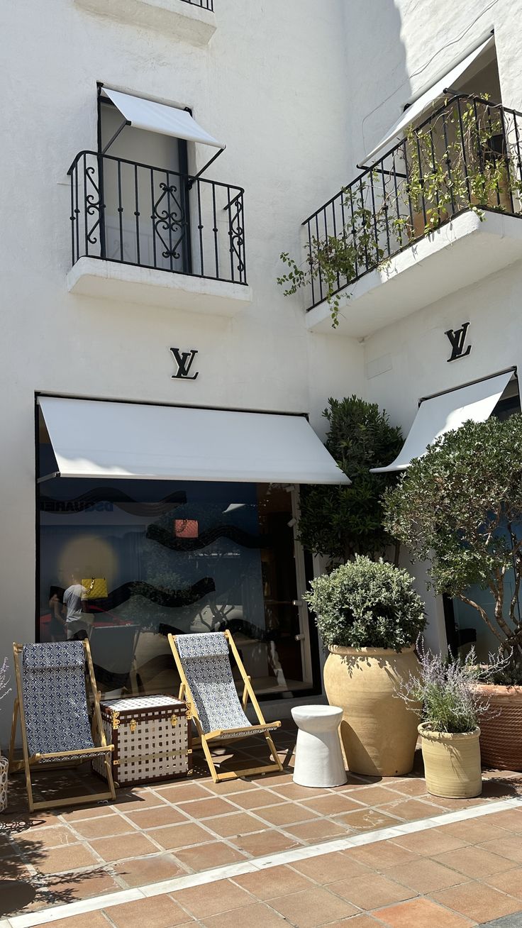 the outside of a building with chairs and plants